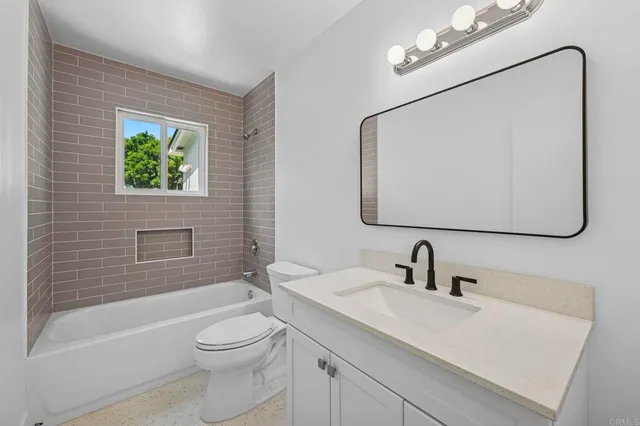 a bathroom with a toilet a sink a mirror and bathtub