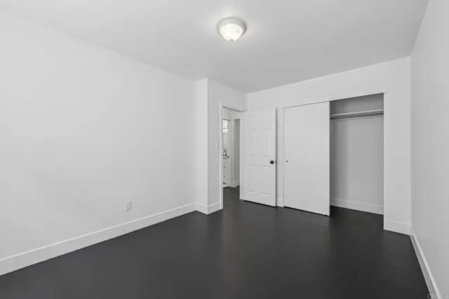 an empty room with wooden floor and white walls