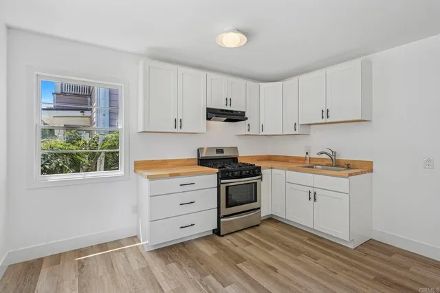 a kitchen with granite countertop white cabinets and white appliances