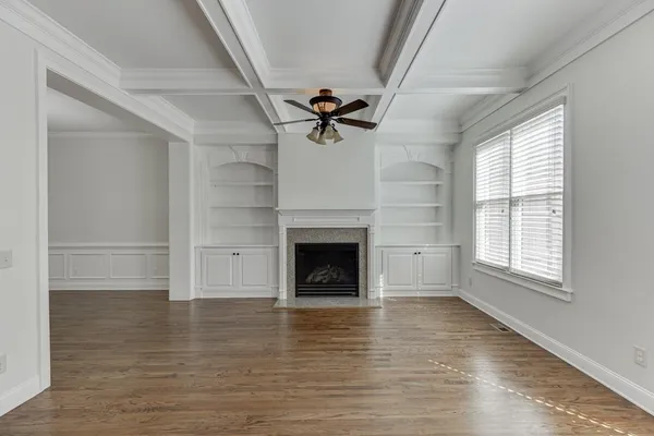 an empty room with a ceiling fan and carpet