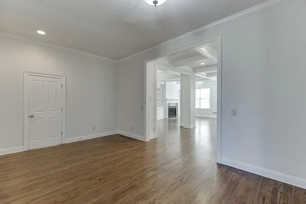 an empty room with wooden floor and mirror