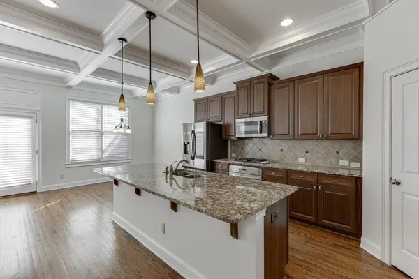 a kitchen with stainless steel appliances granite countertop a refrigerator a sink and a stove