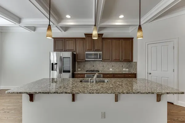 a kitchen with stainless steel appliances granite countertop a sink refrigerator and cabinets