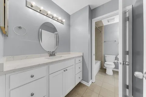 a bathroom with a toilet a sink and mirror