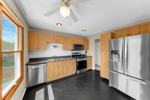 a kitchen with stainless steel appliances granite countertop a refrigerator a stove a sink and a refrigerator