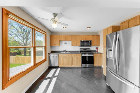 a kitchen with stainless steel appliances a stove top oven and a refrigerator
