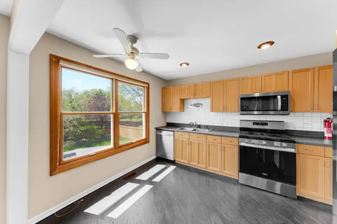 a kitchen with stainless steel appliances granite countertop a stove top oven a sink a counter space and cabinets