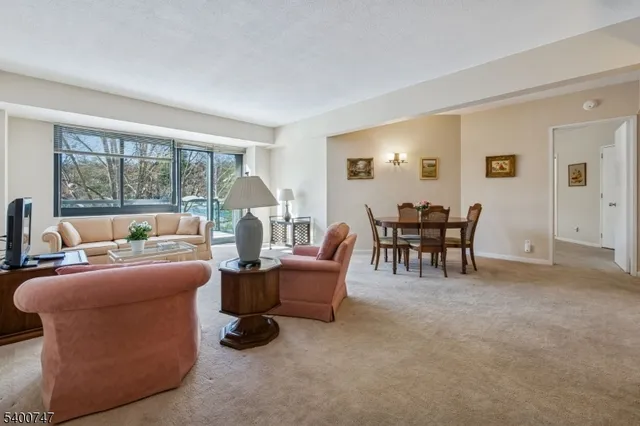 a living room with fireplace furniture and a large window