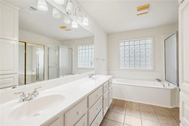 a spacious bathroom with a tub sink and mirror