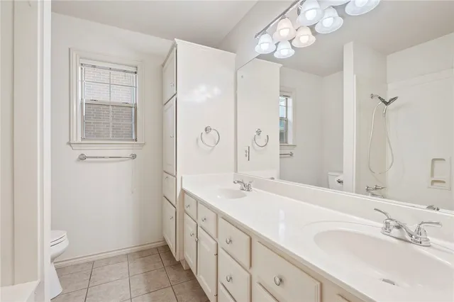 a spacious bathroom with a double vanity sink mirror and a toilet