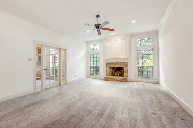 a view of an empty room with a fireplace and a window