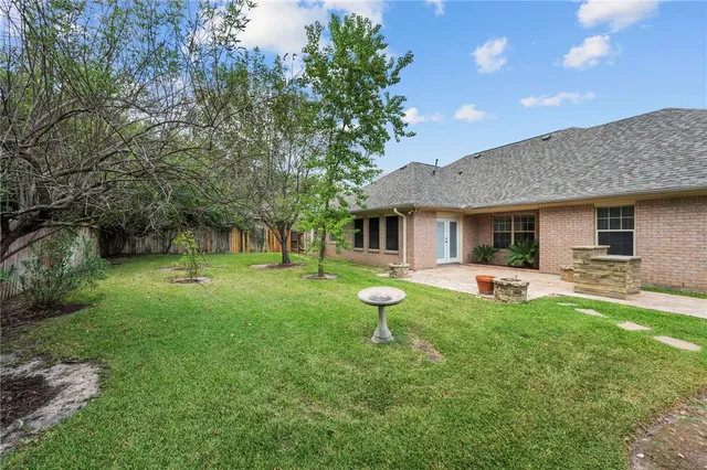 a front view of a house with yard and a garden
