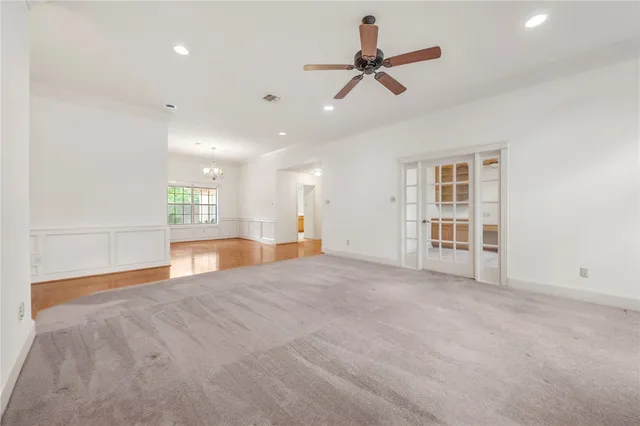 a view of an empty room with a window and a kitchen