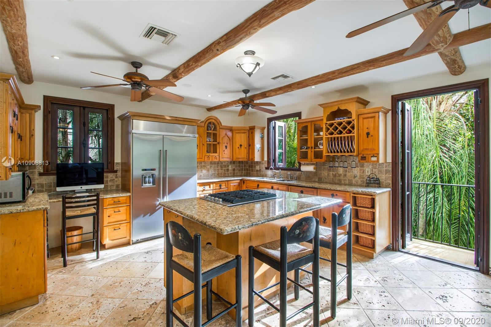385 Ridgewood Road Key Biscayne, FL 33149 - Photo 16 of 54 a dining hall with stainless steel appliances granite countertop a stove a sink a dining table and chairs with the wooden floor