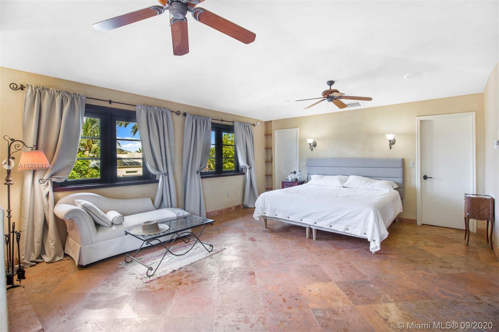 385 Ridgewood Road Key Biscayne, FL 33149 - Photo 23 of 54 a bedroom with a bed a couch and windows