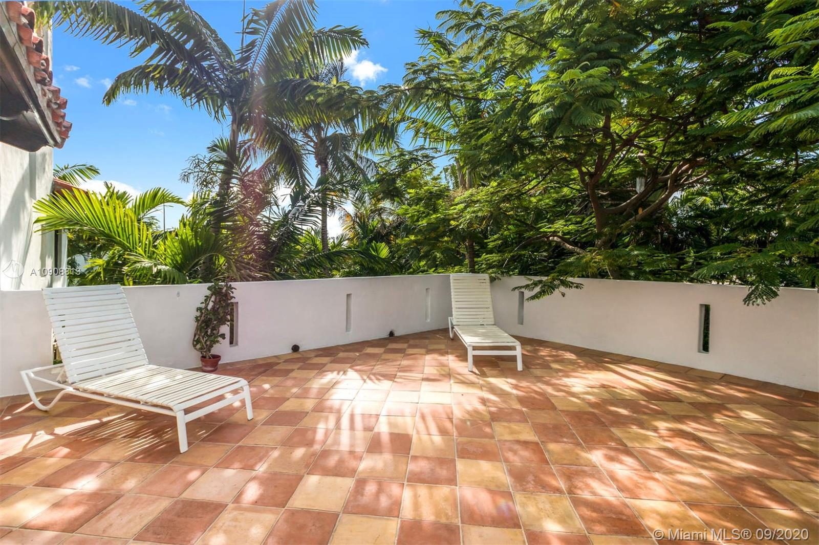 385 Ridgewood Road Key Biscayne, FL 33149 - Photo 24 of 54 a view of a chairs and bench in a backyard