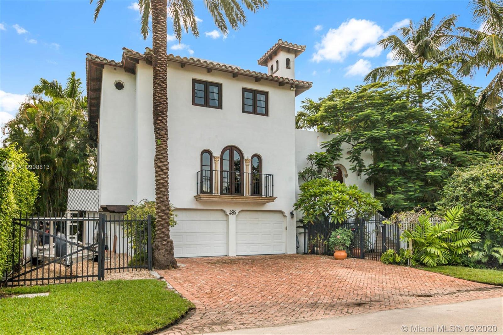 385 Ridgewood Road Key Biscayne, FL 33149 - Photo 3 of 54 a view of a white house with a yard and potted plants