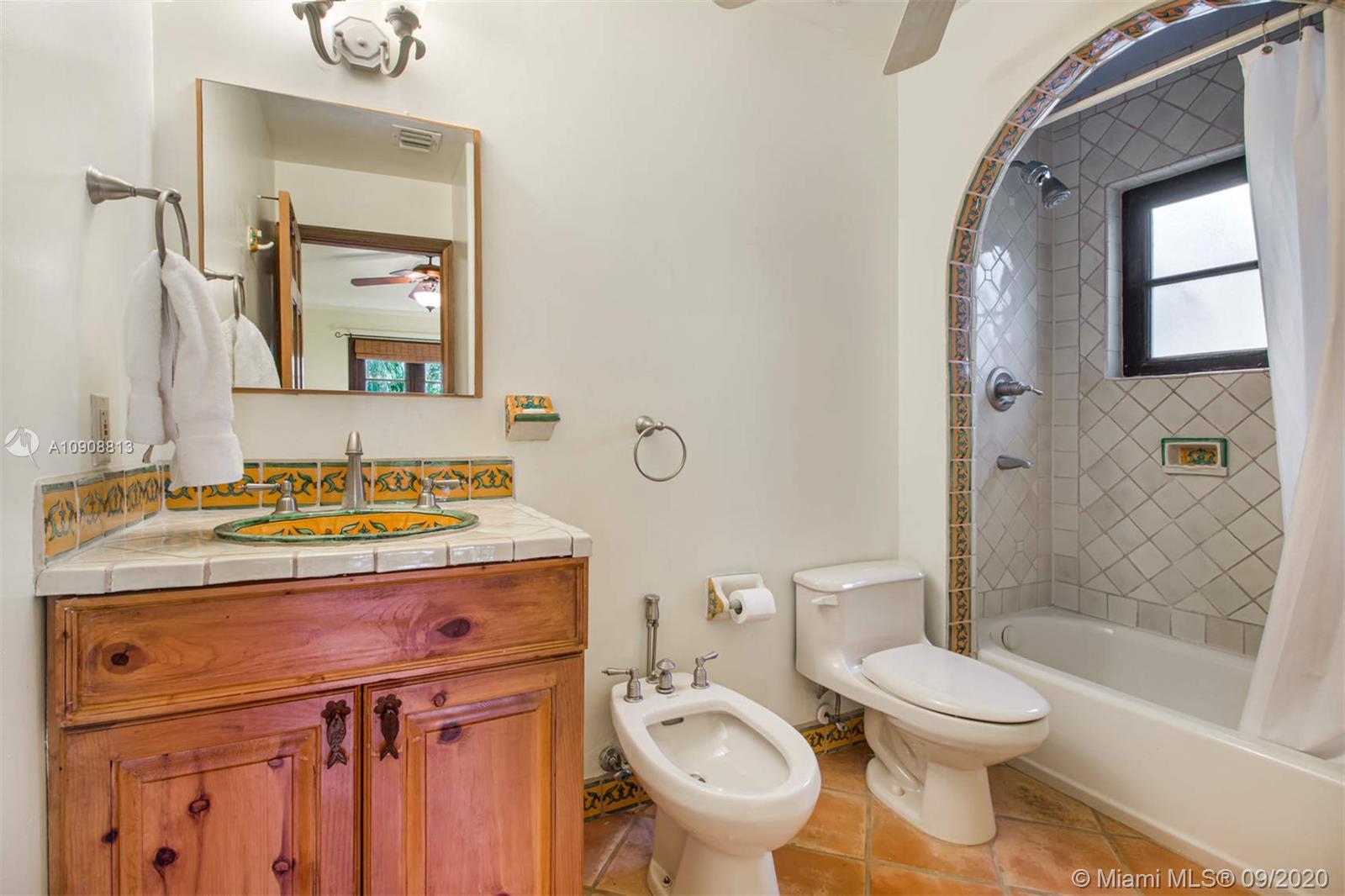 385 Ridgewood Road Key Biscayne, FL 33149 - Photo 35 of 54 a bathroom with a granite countertop toilet sink and mirror