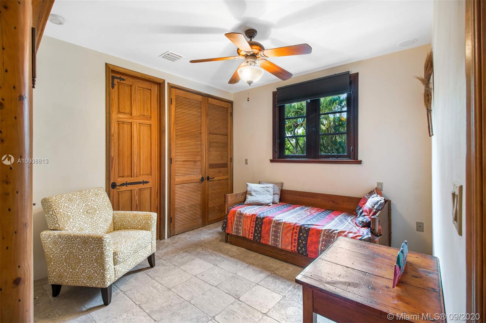 385 Ridgewood Road Key Biscayne, FL 33149 - Photo 39 of 54 a bedroom with furniture and a ceiling fan