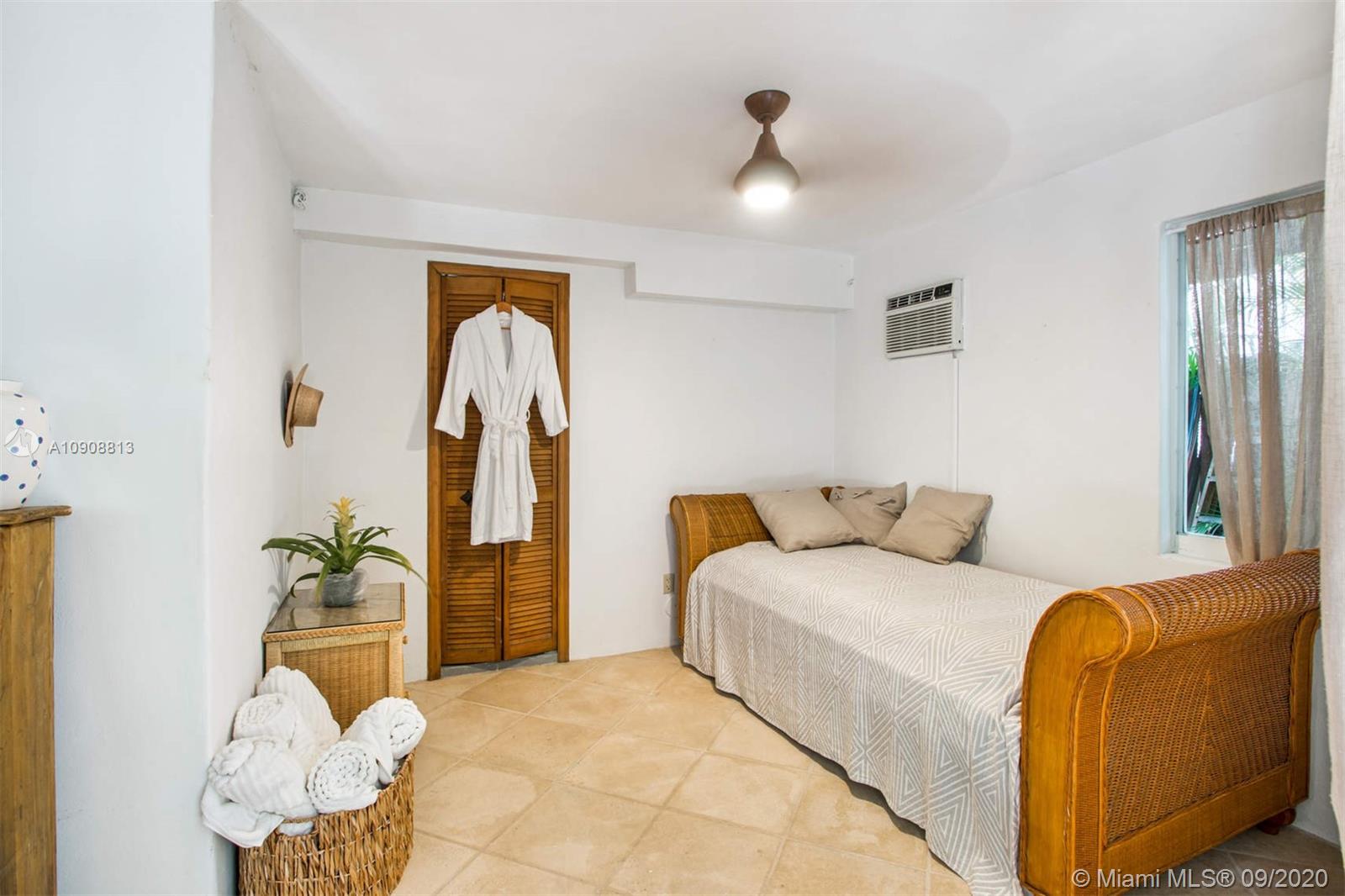 385 Ridgewood Road Key Biscayne, FL 33149 - Photo 40 of 54 a bedroom with a bed and a chandelier