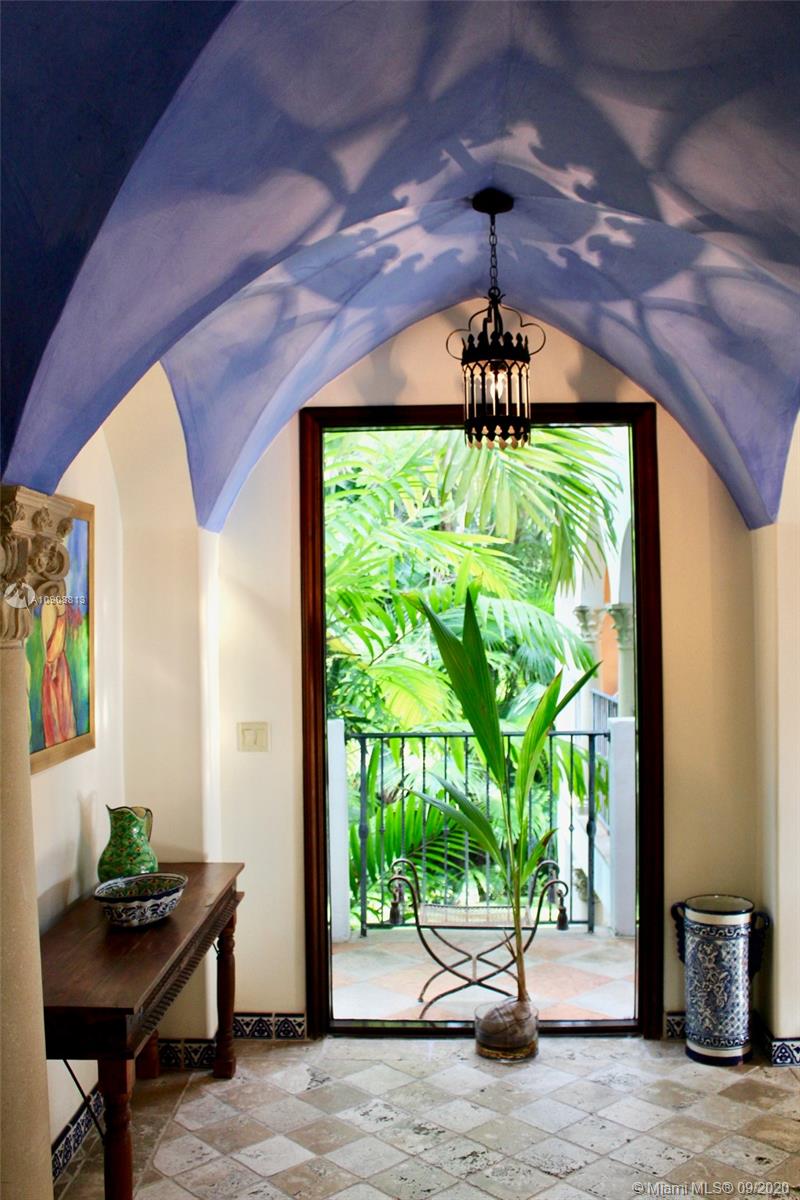 385 Ridgewood Road Key Biscayne, FL 33149 - Photo 9 of 54 a vase of flowers sitting on a table in front of a window