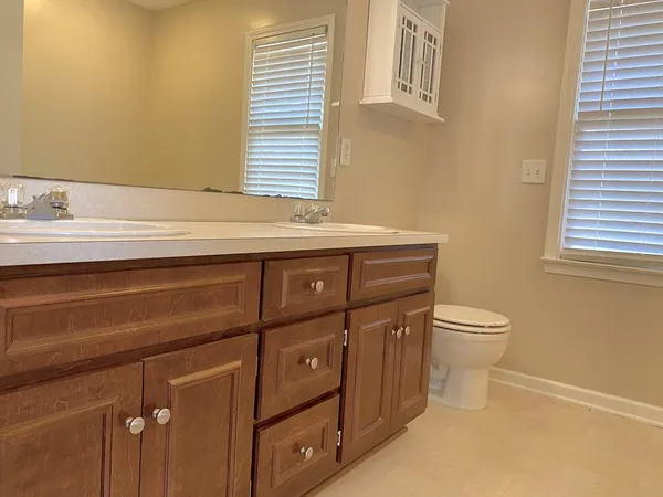 a bathroom with a sink a toilet and a window