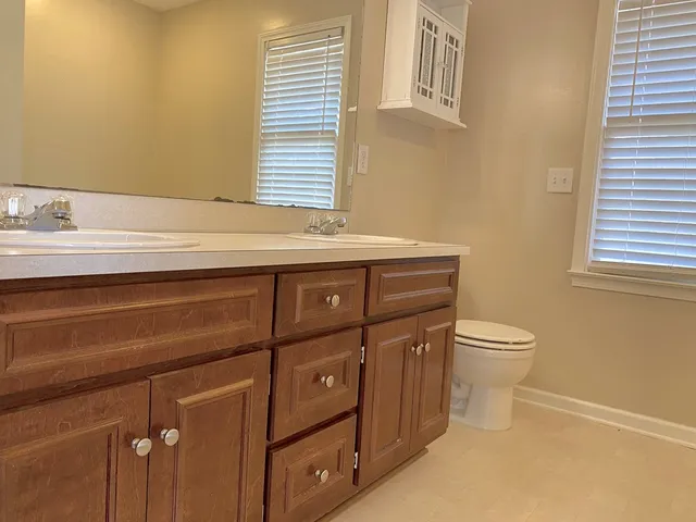 a bathroom with a sink a toilet and a window