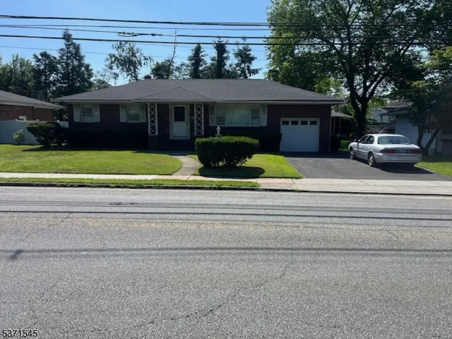 a front view of a house with a garden and trees