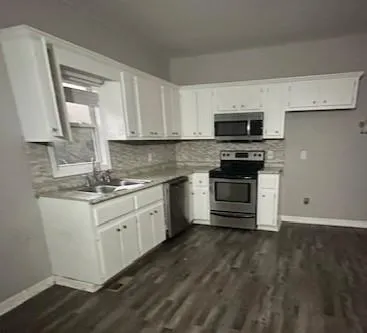 a kitchen with stainless steel appliances granite countertop a stove a sink and a microwave