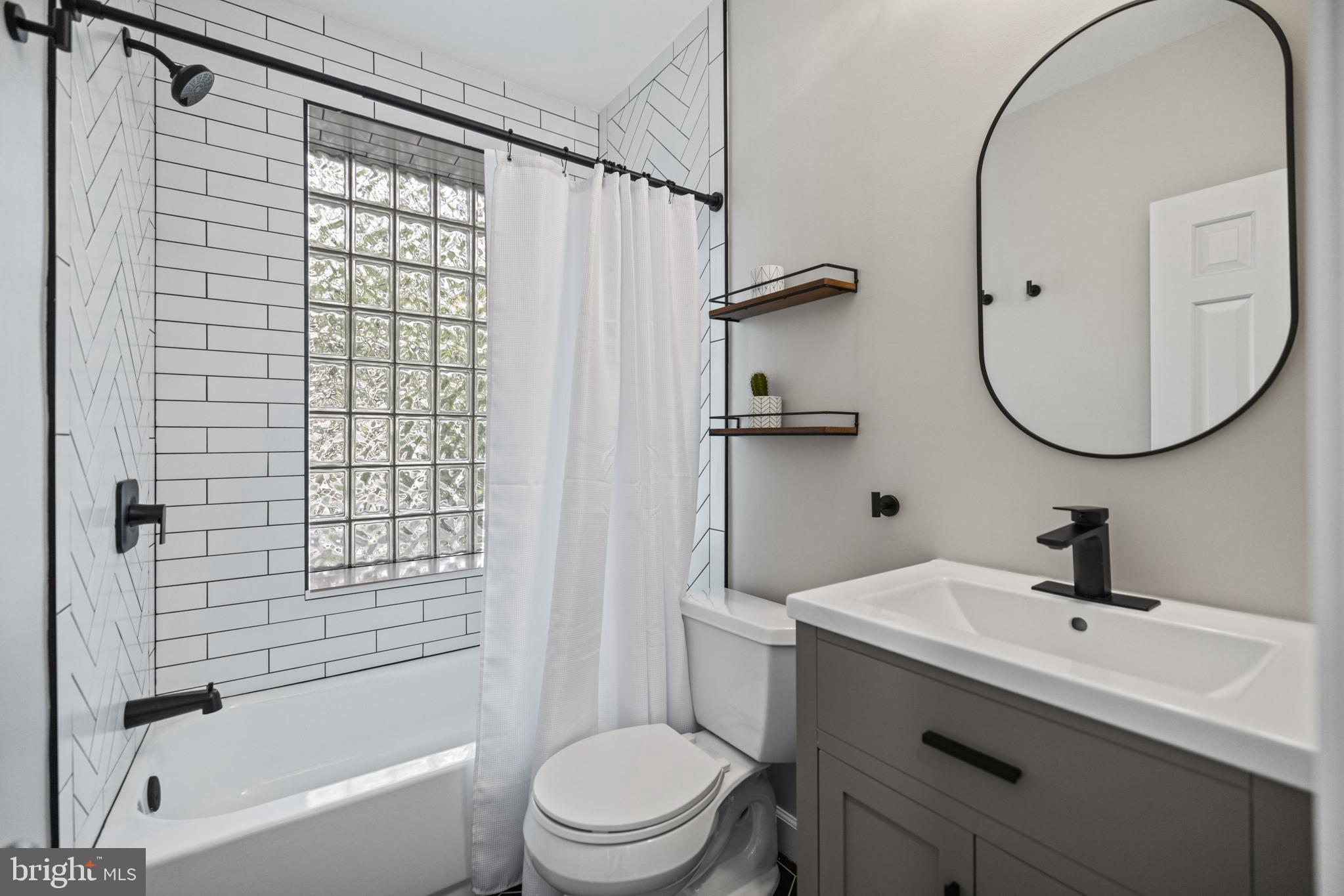 5212 MacArthur Boulevard Northwest Washington, DC 20016 - Photo 32 of 59 a bathroom with a sink a toilet and a mirror