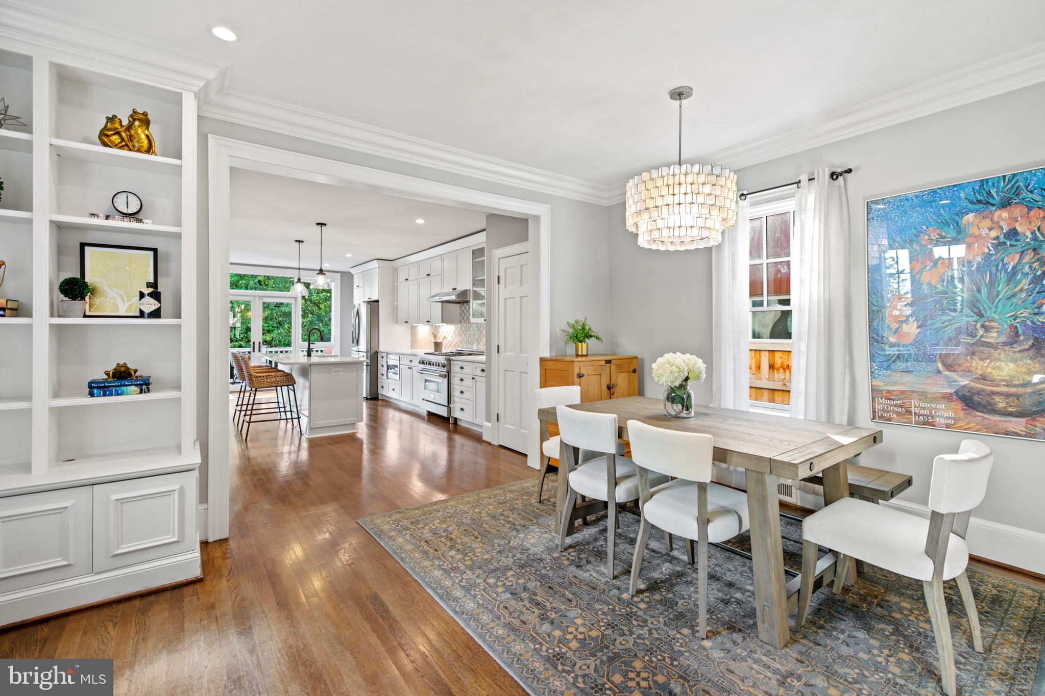 5212 MacArthur Boulevard Northwest Washington, DC 20016 - Photo 4 of 59 a dining room with wooden floor a chandelier a glass table and chairs