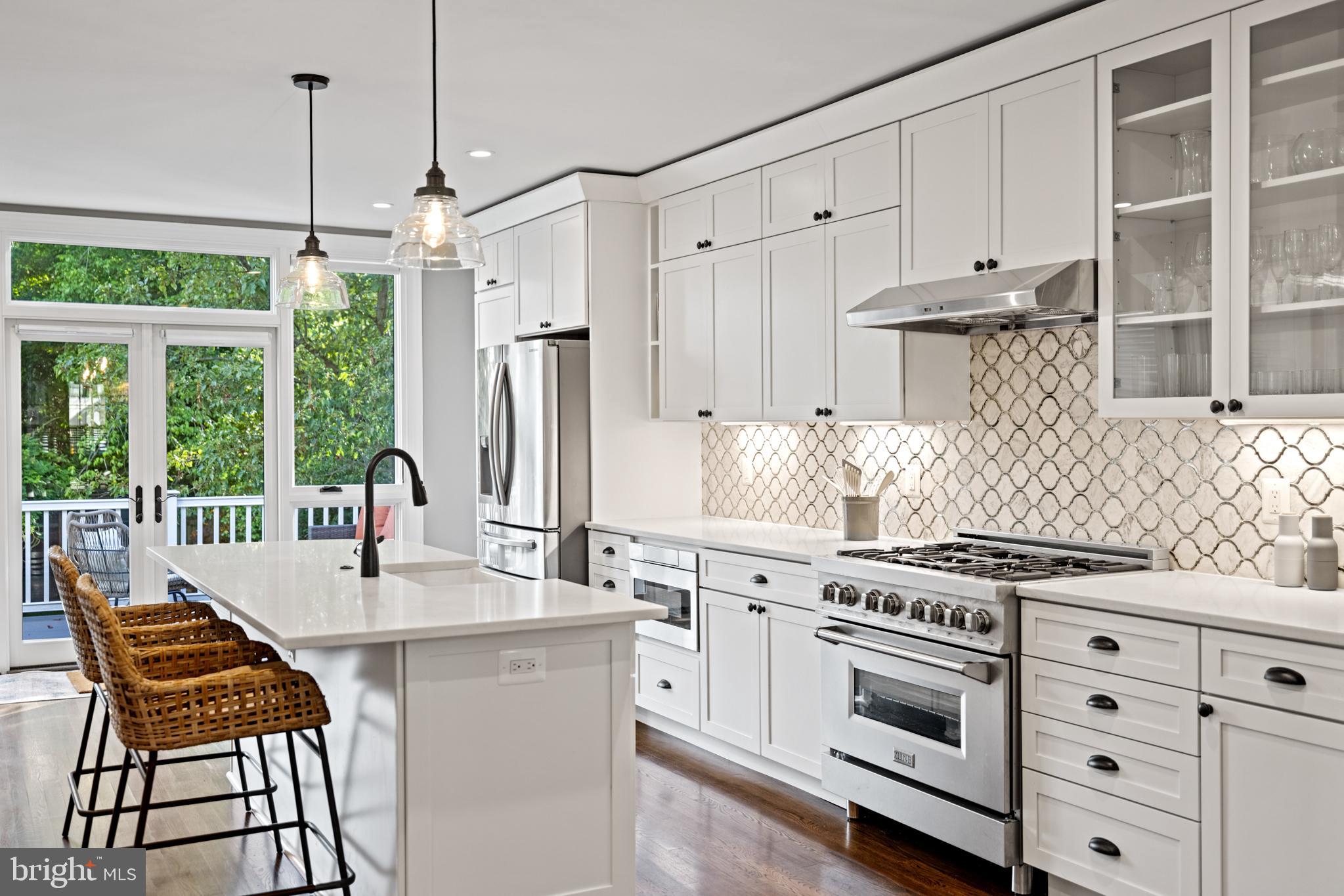 5212 MacArthur Boulevard Northwest Washington, DC 20016 - Photo 6 of 59 a kitchen with stainless steel appliances a stove a sink and cabinets