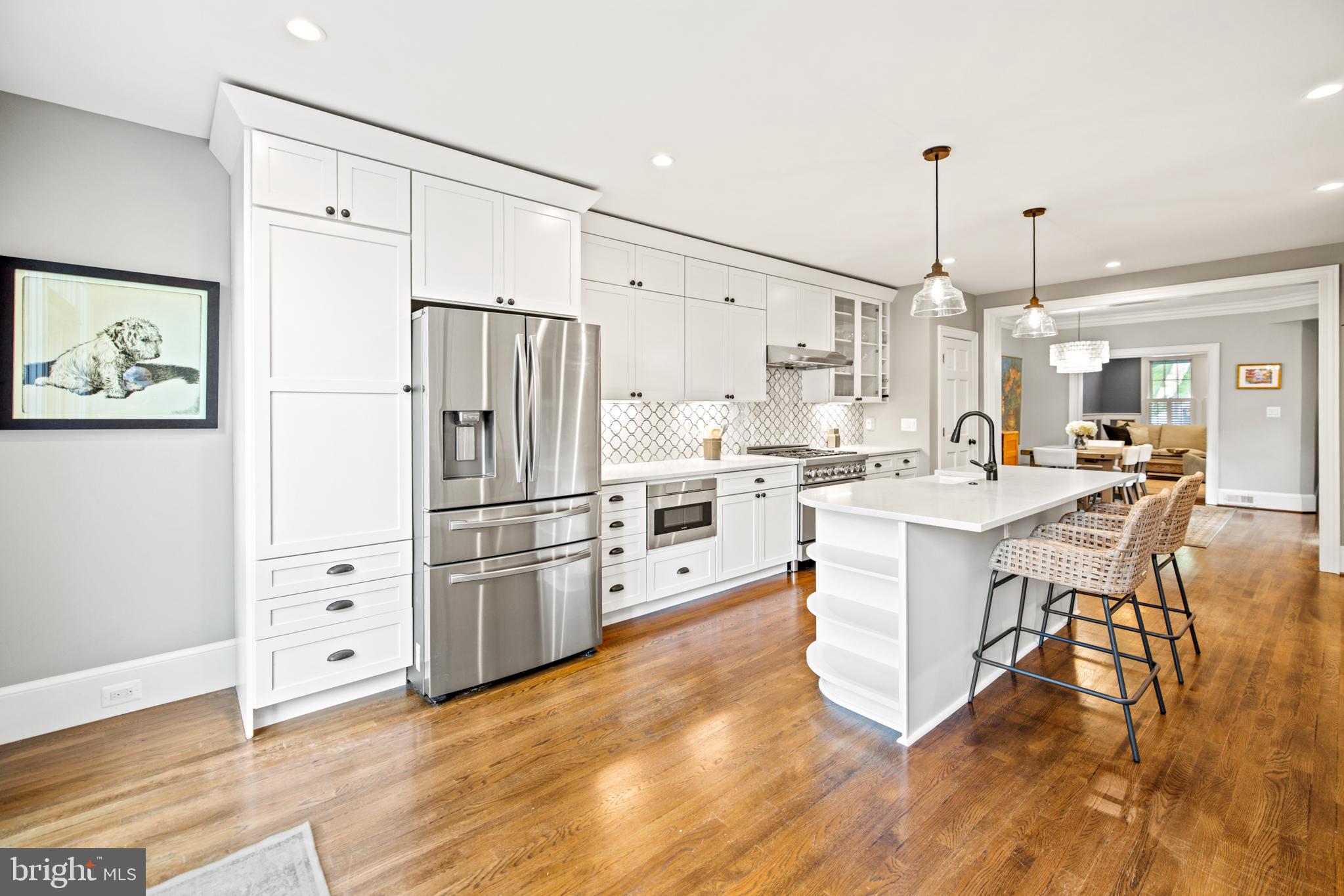5212 MacArthur Boulevard Northwest Washington, DC 20016 - Photo 9 of 59 a kitchen with stainless steel appliances kitchen island granite countertop a refrigerator a stove a sink and white cabinets with wooden floor