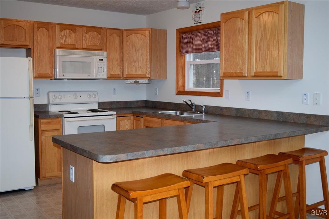 290 Brier Crest Road Blakeslee, PA 18610 - Photo 17 of 43 a kitchen with stainless steel appliances granite countertop a sink a stove and a microwave