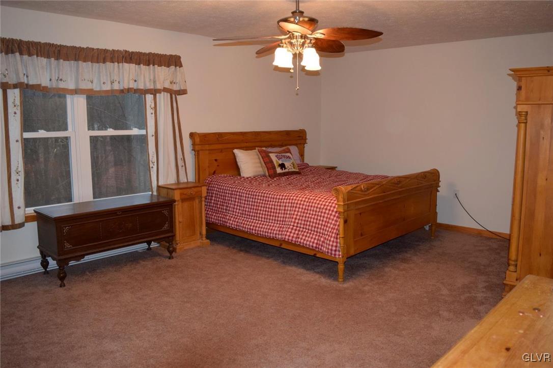 290 Brier Crest Road Blakeslee, PA 18610 - Photo 23 of 43 a bedroom with a bed and a chandelier