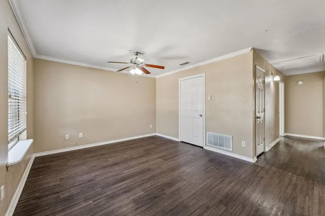 a view of an empty room with wooden floor