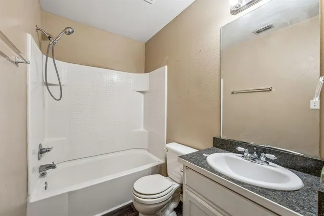a bathroom with a granite countertop sink toilet mirror and shower