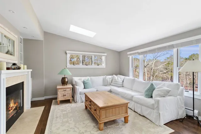 a living room with furniture a flat screen tv and a fireplace