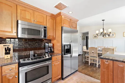 a kitchen with stainless steel appliances granite countertop a stove refrigerator and a microwave