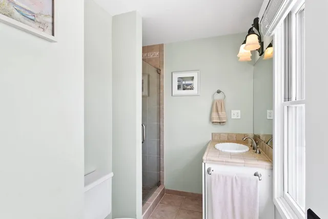a bathroom with a sink and mirror with window