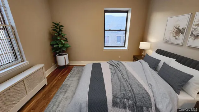 a bedroom with a bed and a potted plant on the dresser