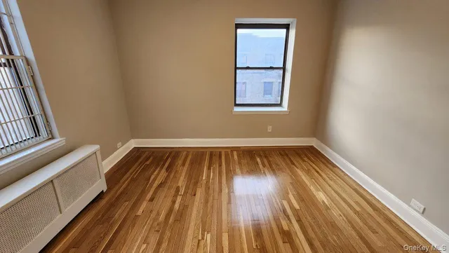 a view of a room with wooden floor and window