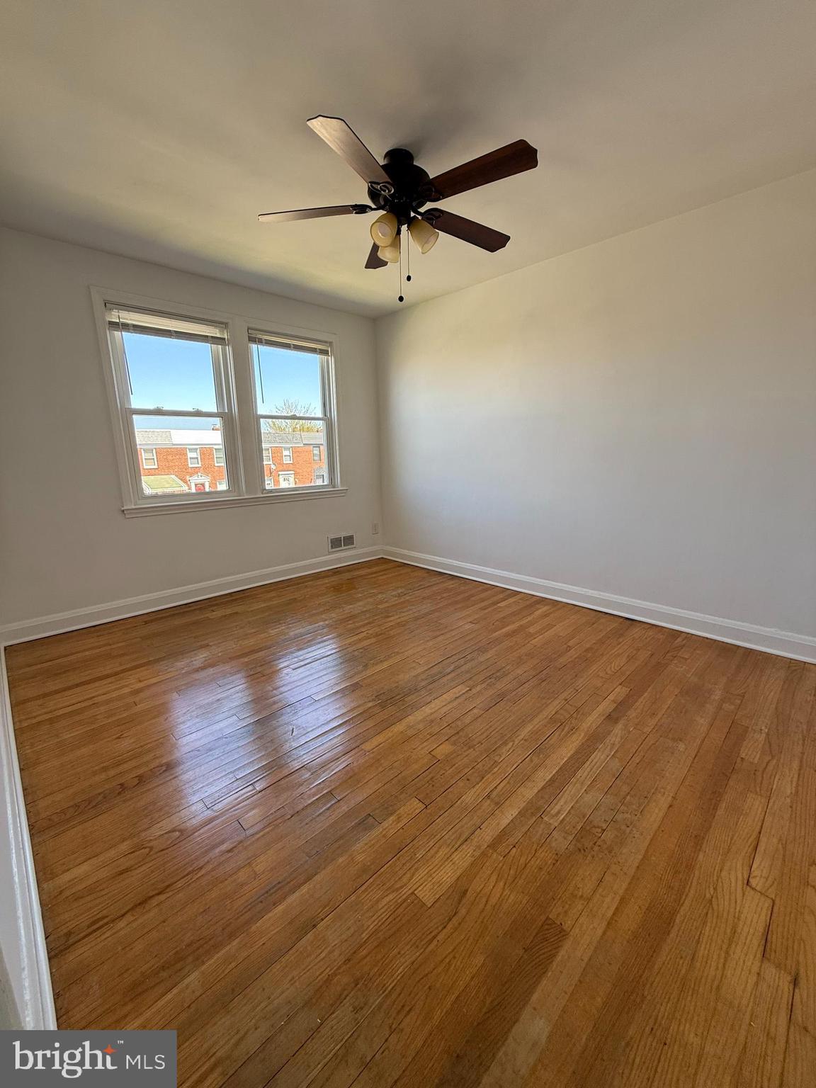 3731 Bonview Avenue, Unit 2B Baltimore, MD 21213 - Photo 12 of 14 an empty room with wooden floor fan and windows