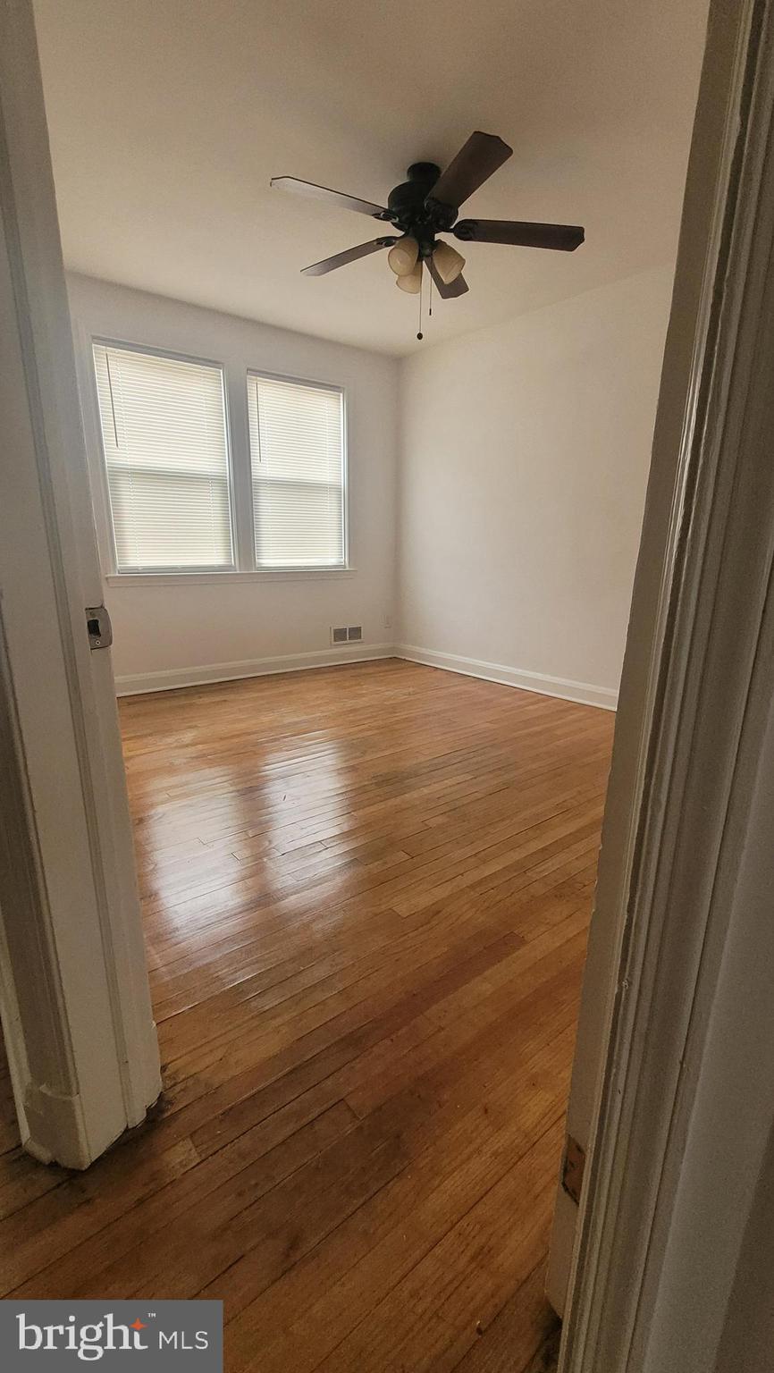 3731 Bonview Avenue, Unit 2B Baltimore, MD 21213 - Photo 7 of 14 a view of an empty room with wooden floor and a window