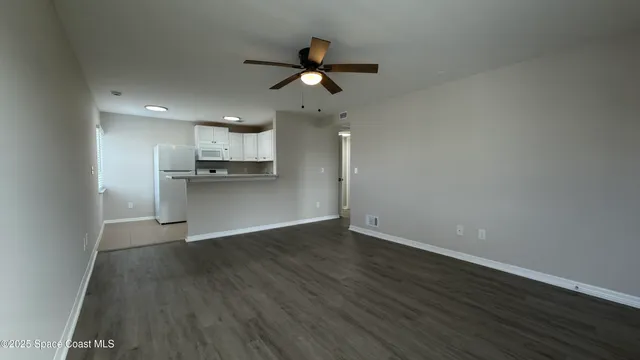 a view of a kitchen with a sink a ceiling fan and stainless steel appliances