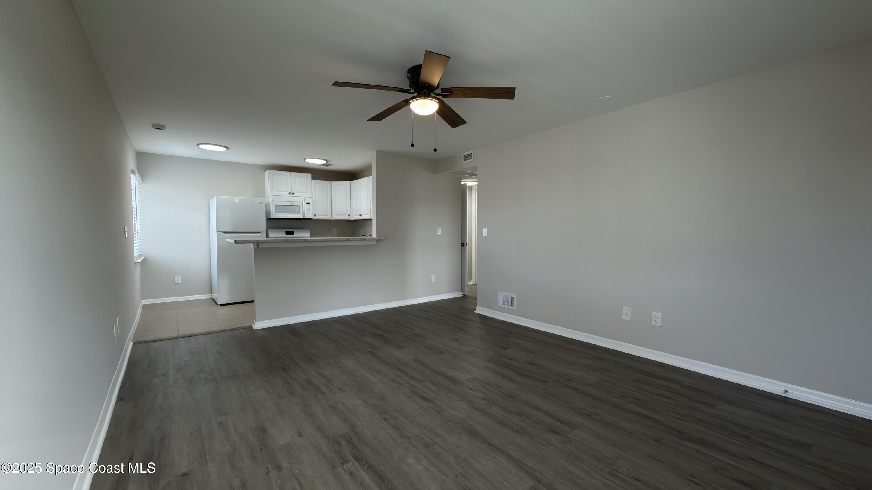 800 North Fiske Boulevard, Unit 709 Cocoa, FL 32922 - Photo 4 of 11 a view of a kitchen with a sink a ceiling fan and stainless steel appliances