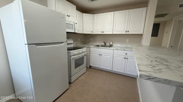 a kitchen with stainless steel appliances granite countertop a stove a refrigerator and a sink
