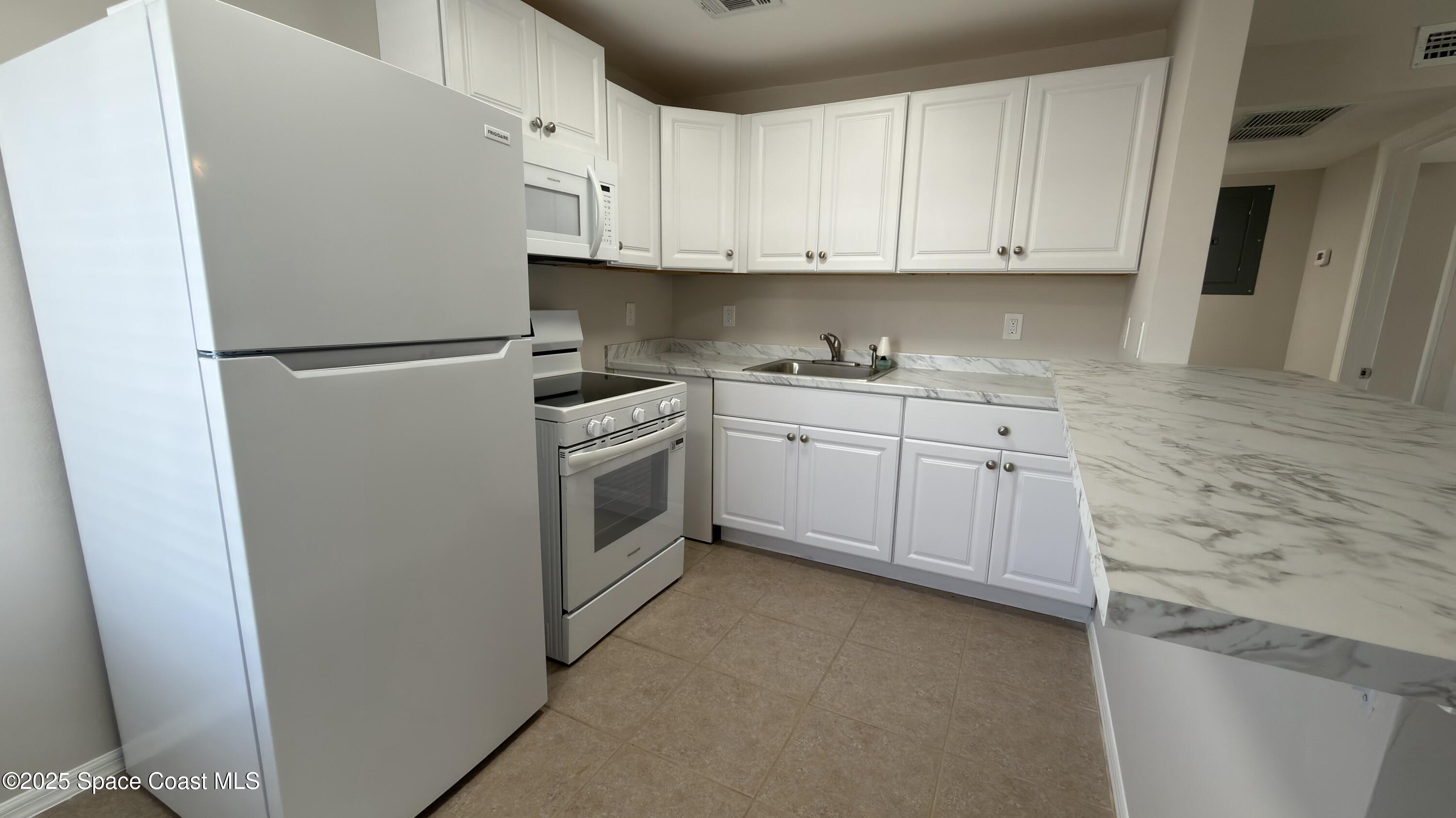 800 North Fiske Boulevard, Unit 709 Cocoa, FL 32922 - Photo 8 of 11 a kitchen with stainless steel appliances granite countertop a stove a refrigerator and a sink