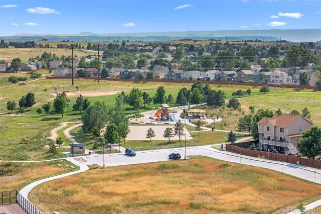 a view of a green field with mountains in the background