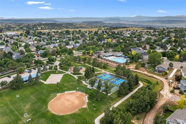 an aerial view of a city with lots of residential buildings and mountain view in back